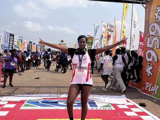 A runner crossing the finish line, arms out